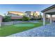 A landscaped backyard featuring a custom putting green and a paved patio area creates an ideal space for relaxation at 10116 Rebel Coast St, Las Vegas, NV 89141