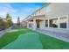 Landscaped backyard features a custom putting green, covered patio, and large windows offer seamless indoor-outdoor living at 10116 Rebel Coast St, Las Vegas, NV 89141