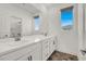 Bright bathroom features a double sink vanity, modern fixtures, and a window for natural light at 10116 Rebel Coast St, Las Vegas, NV 89141