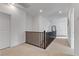 A bright hallway with a wooden railing and neutral carpet at 10116 Rebel Coast St, Las Vegas, NV 89141