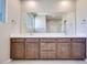 Double vanity bathroom with modern wood cabinets and large mirror at 11904 Vector Ray Ave, Las Vegas, NV 89138