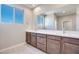Double vanity bathroom with modern wood cabinets and large mirror at 11904 Vector Ray Ave, Las Vegas, NV 89138