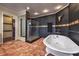 A luxurious bathroom featuring a clawfoot tub, glass shower, and dark tile accent wall at 1420 S 8Th St, Las Vegas, NV 89104
