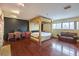Spacious main bedroom suite with hardwood floors, four-poster bed, and desk area at 1420 S 8Th St, Las Vegas, NV 89104