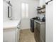 Bright laundry room with modern appliances, white cabinets and countertop, and a window with plantation shutters at 1838 Country Meadows Dr, Henderson, NV 89012