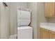 Bright laundry room with stackable washer and dryer, and cabinets at 19 Via Visione # 204, Henderson, NV 89011