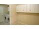 Bright laundry room, washer, dryer, and upper cabinets at 3390 Syvella Ct, Las Vegas, NV 89117