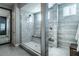Modern primary bathroom showcasing luxurious marble and glass enclosed walk-in shower with bench at 4269 Solace St # 0, Las Vegas, NV 89135