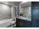 Modern bathroom featuring a shower-tub combination, dark cabinets and a large mirror at 4269 Solace St # 0, Las Vegas, NV 89135