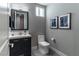Well-lit half bathroom with modern fixtures, a floating vanity, and contemporary wall art at 4269 Solace St # 0, Las Vegas, NV 89135