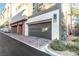 View of the garages with grey doors, surrounded by pavers and desert landscaping at 4269 Solace St # 0, Las Vegas, NV 89135