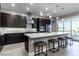 Modern kitchen features a large island with seating, stainless steel appliances, and stylish backsplash at 4269 Solace St # 0, Las Vegas, NV 89135