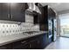 Modern kitchen featuring sleek dark cabinetry, stainless steel appliances, and stylish backsplash at 4269 Solace St # 0, Las Vegas, NV 89135