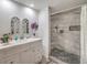 Bright bathroom with a double sink vanity and a walk-in shower featuring gray stone tiles and a pebble floor at 508 Indian Princess Dr # 101, Las Vegas, NV 89145