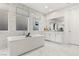 Elegant bathroom featuring marble, a soaking tub, and large windows at 5219 Iron River Ct, Las Vegas, NV 89135