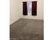 Simple carpeted bedroom with window and maroon curtains at 5751 E Hacienda Ave # 118, Las Vegas, NV 89122