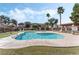 Community pool with surrounding lawn and trees at 5751 E Hacienda Ave # 118, Las Vegas, NV 89122