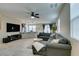 Spacious living room with L-shaped sectional sofa, large TV, and kitchen island at 6966 Placid Lake Ave, Las Vegas, NV 89179