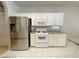 Modern kitchen featuring stainless steel appliances, white cabinetry, and sleek countertops with tile floors at 7633 Winterthur Ct, Las Vegas, NV 89129