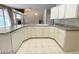 Well-appointed kitchen showcasing white cabinetry, a large countertop, and a view to the dining area and fireplace at 7633 Winterthur Ct, Las Vegas, NV 89129