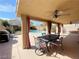 Inviting covered patio with ceiling fan and view of pool and backyard at 7633 Winterthur Ct, Las Vegas, NV 89129