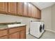 Laundry room with washer, dryer, and wood cabinets at 9472 Ojibwa Ave, Las Vegas, NV 89149