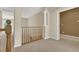Upstairs hallway with wooden railing and neutral carpeting at 9472 Ojibwa Ave, Las Vegas, NV 89149