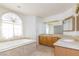 Spacious bathroom with corner vanity, soaking tub, and glass block accents at 1010 Legacy Dr, Boulder City, NV 89005