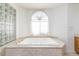 Bathroom with soaking tub, double vanity, and glass block feature wall at 1010 Legacy Dr, Boulder City, NV 89005