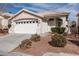 Single-story house with a two-car garage and well-maintained landscaping at 10540 Beachwalk Pl, Las Vegas, NV 89144