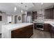 Spacious kitchen featuring an island, dark wood cabinets, stainless steel appliances, and open to the living room at 10936 White Alder Pl, Las Vegas, NV 89138