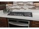 Close up of stovetop and built-in oven showcasing modern design and stainless steel appliances with quartz countertops at 10936 White Alder Pl, Las Vegas, NV 89138