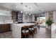 Modern kitchen features a center island, dark wood cabinetry, and leads to an outdoor dining space and pool at 10936 White Alder Pl, Las Vegas, NV 89138