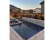 Beautiful pool area with spa, string lights, and lush plants set against a charming residential backdrop at 10936 White Alder Pl, Las Vegas, NV 89138