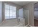 Bright bathroom features a soaking tub under a window and glass-enclosed shower at 11106 Cherokee Landing St, Las Vegas, NV 89179