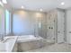 Elegant bathroom with soaking tub, walk-in shower, and quartz countertops at 12846 Ringrose St, Las Vegas, NV 89141