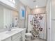 Clean bathroom with white vanity, floral shower curtain, and tile floor at 12846 Ringrose St, Las Vegas, NV 89141