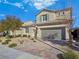 Tan two-story house with tile roof, shutters, and a gray garage door at 12846 Ringrose St, Las Vegas, NV 89141