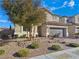 Landscaped front yard with trees, shrubs, and brick walkway at 12846 Ringrose St, Las Vegas, NV 89141