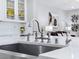 Modern kitchen sink and faucet with white quartz countertops at 12846 Ringrose St, Las Vegas, NV 89141