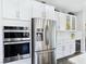 Stainless steel appliances and double oven in a white kitchen at 12846 Ringrose St, Las Vegas, NV 89141