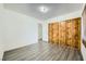 Bedroom with wood-look floors and mirrored closet doors at 1688 Crest Ave, Las Vegas, NV 89119