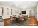 Virtually staged dining room with hardwood floors and a large table at 2 Lago Turchino Ct, Henderson, NV 89011