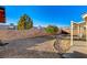 Backyard with gravel landscaping, small trees, and a covered patio area at 2177 Bridle Wreath Ln, Las Vegas, NV 89156