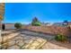 View of the backyard with gravel landscaping, stone patio, and a block wall for privacy at 2177 Bridle Wreath Ln, Las Vegas, NV 89156