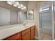 Bathroom featuring a large mirror, ample vanity counter space, and a shower with sliding glass doors at 2177 Bridle Wreath Ln, Las Vegas, NV 89156