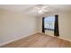 Bright bedroom with a ceiling fan, wood flooring, and a large window with security bars and curtains at 2177 Bridle Wreath Ln, Las Vegas, NV 89156