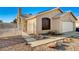 Tan home featuring a two-car garage and a well maintained lawn at 2177 Bridle Wreath Ln, Las Vegas, NV 89156