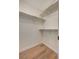 Walk-in closet with built-in shelving and wood-look flooring, maximizing storage space and organization at 2177 Bridle Wreath Ln, Las Vegas, NV 89156