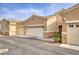 Tan colored stucco home with attached garage and landscaping at 237 Garrett Ln # 2, Boulder City, NV 89005